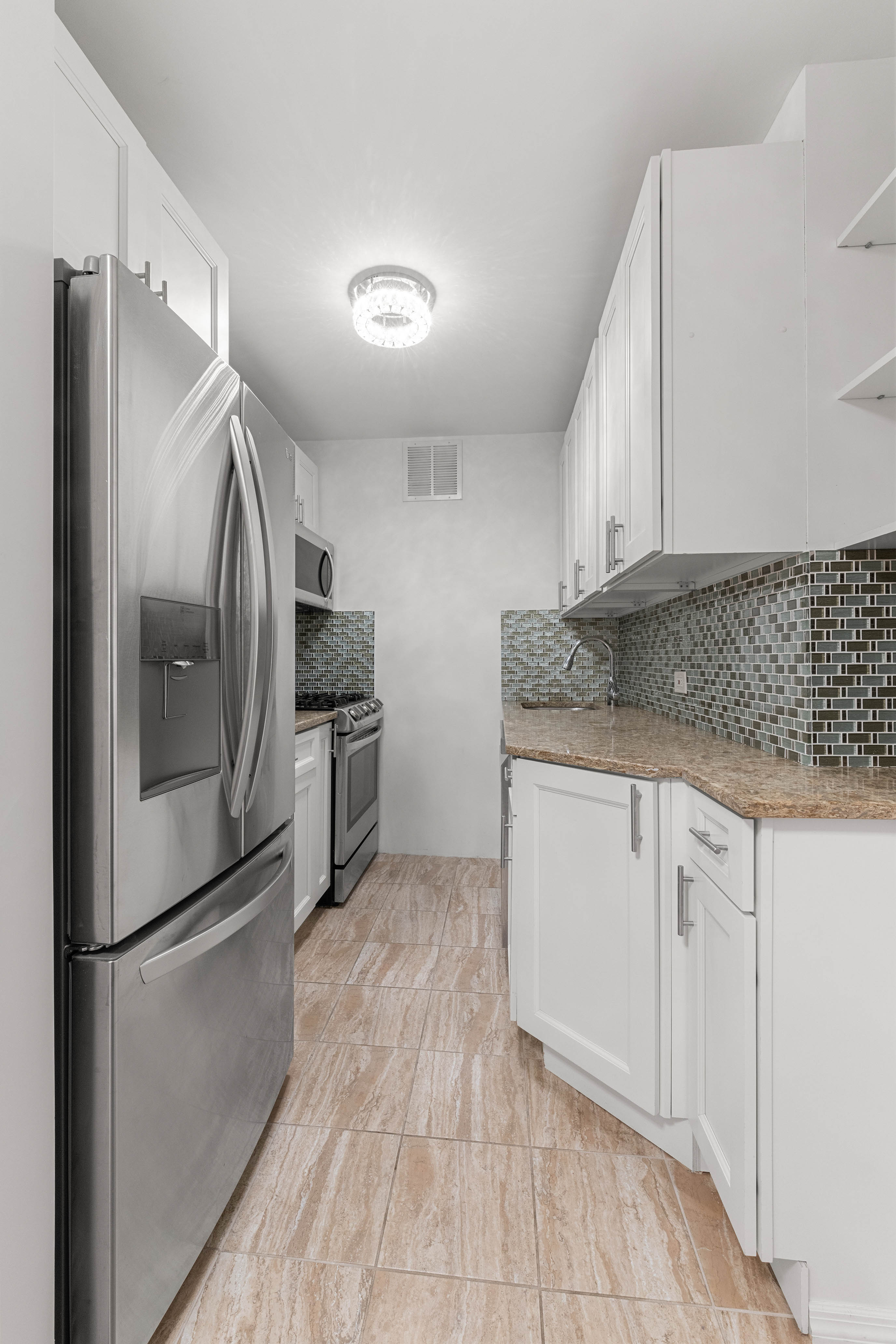 102-10 66th Road, Unit 21K Queens, NY 11375 - Photo 5 of 16 a kitchen with granite countertop a refrigerator and a sink