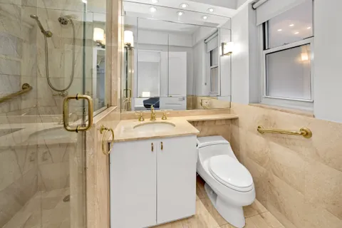 a bathroom with a sink a toilet and shower