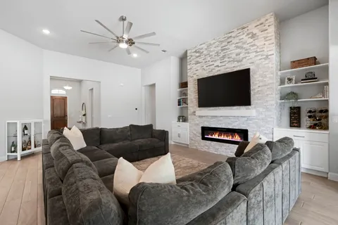 a living room with furniture a fireplace and a flat screen tv