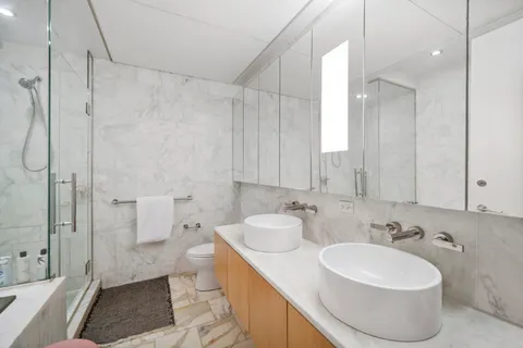 a bathroom with a sink a toilet and shower