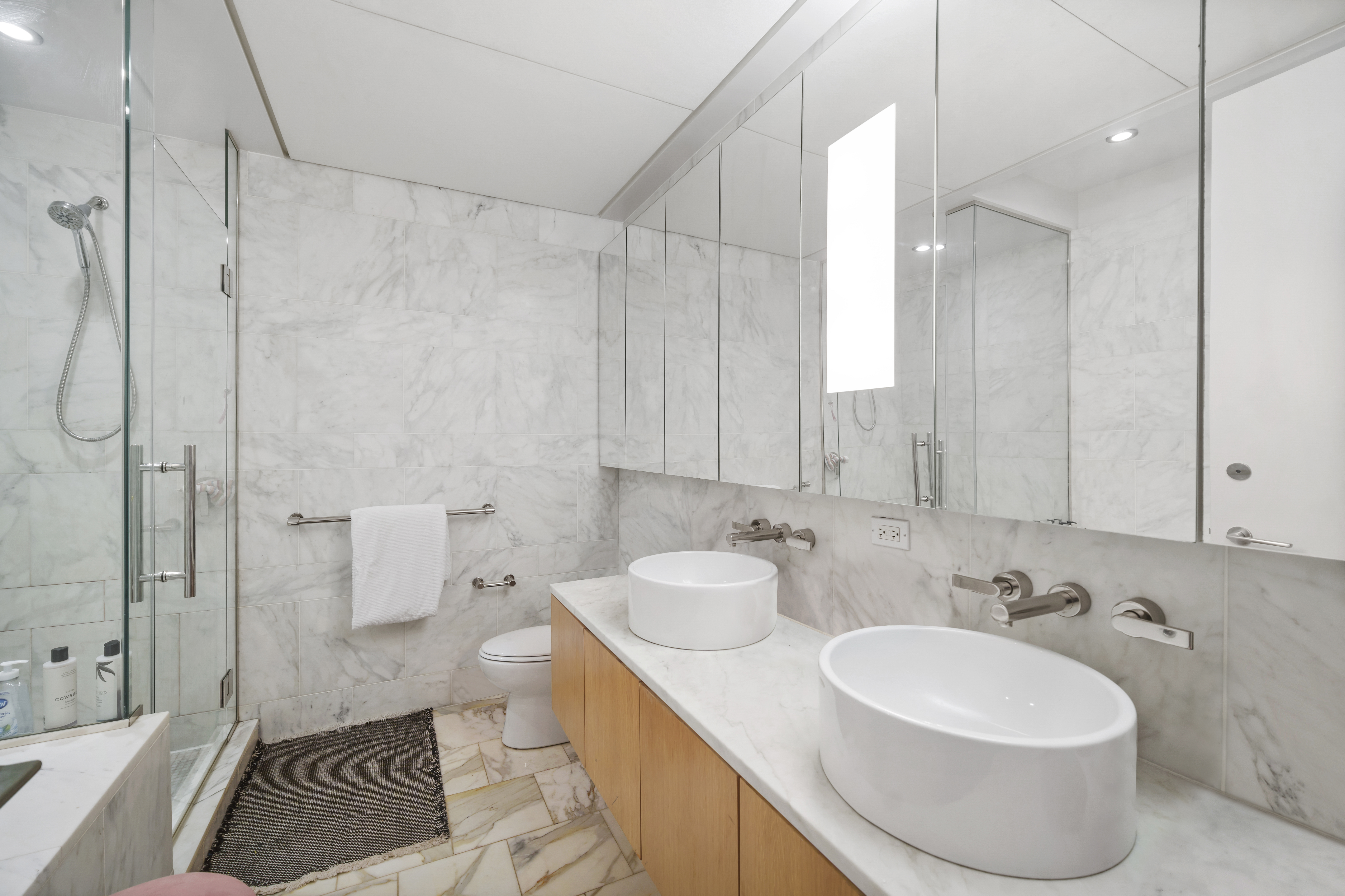 18 West 48th Street, Unit 12E Manhattan, NY 10036 - Photo 7 of 10 a bathroom with a sink a toilet and shower