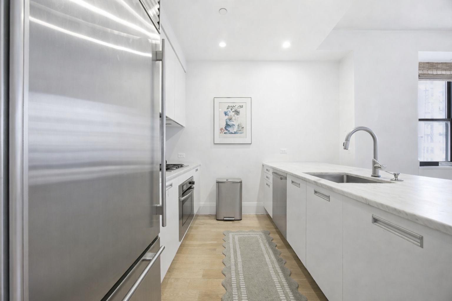 71 Nassau Street, Unit 13C Manhattan, NY 10038 - Photo 11 of 16 a kitchen with a sink and refrigerator