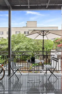 a view of a balcony with chairs and wooden floor