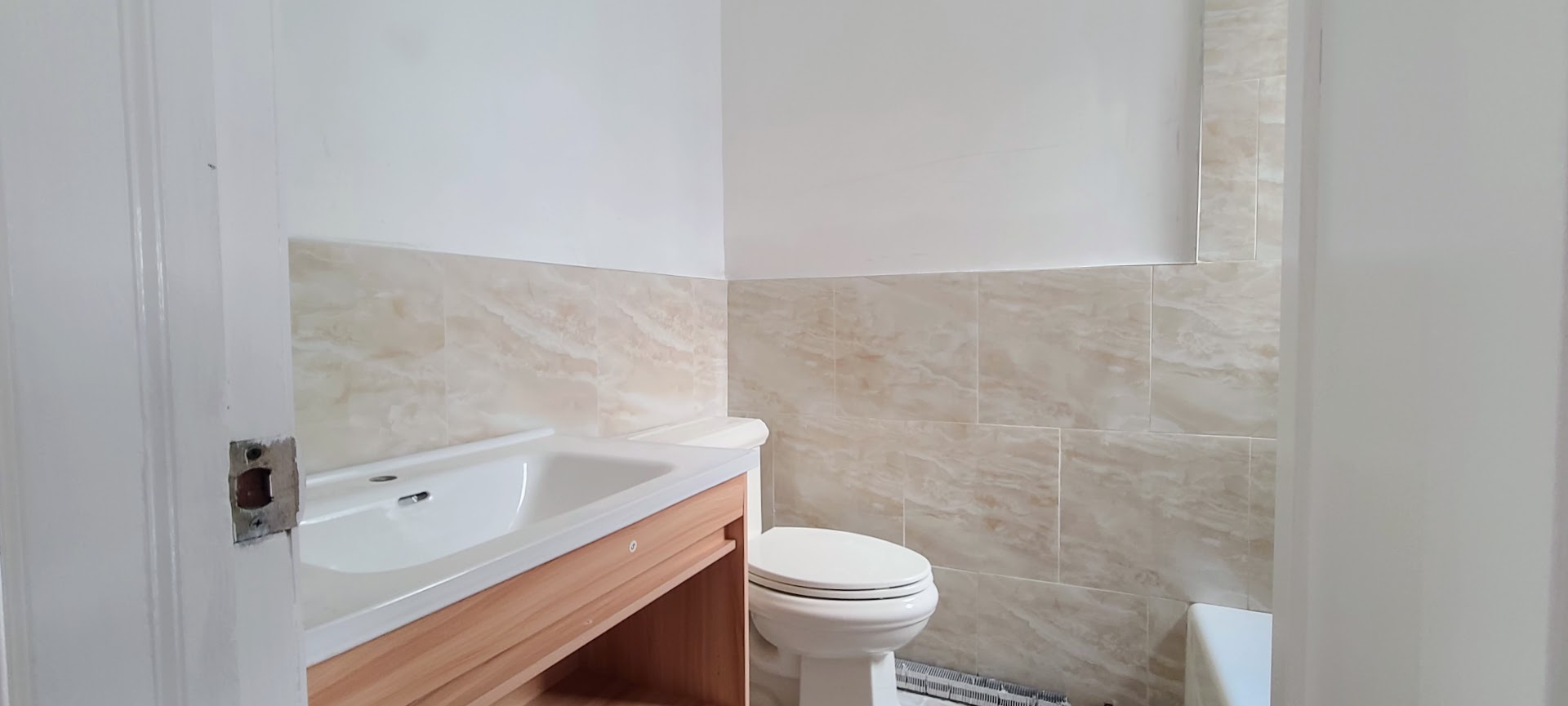 97-08 Plattwood Avenue, Unit 2 Queens, NY 11417 - Photo 9 of 10 a white toilet sitting next to a bathroom sink