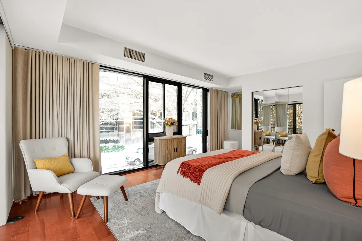 a bedroom with a bed and large windows