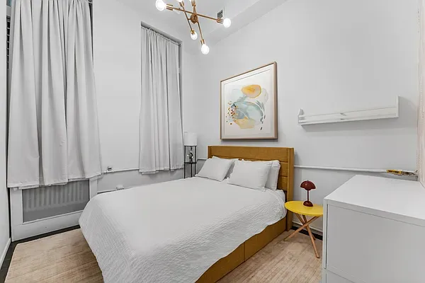 a bedroom with a bed and a painting on the wall