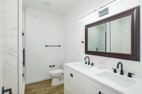 a bathroom with a toilet a sink and a mirror