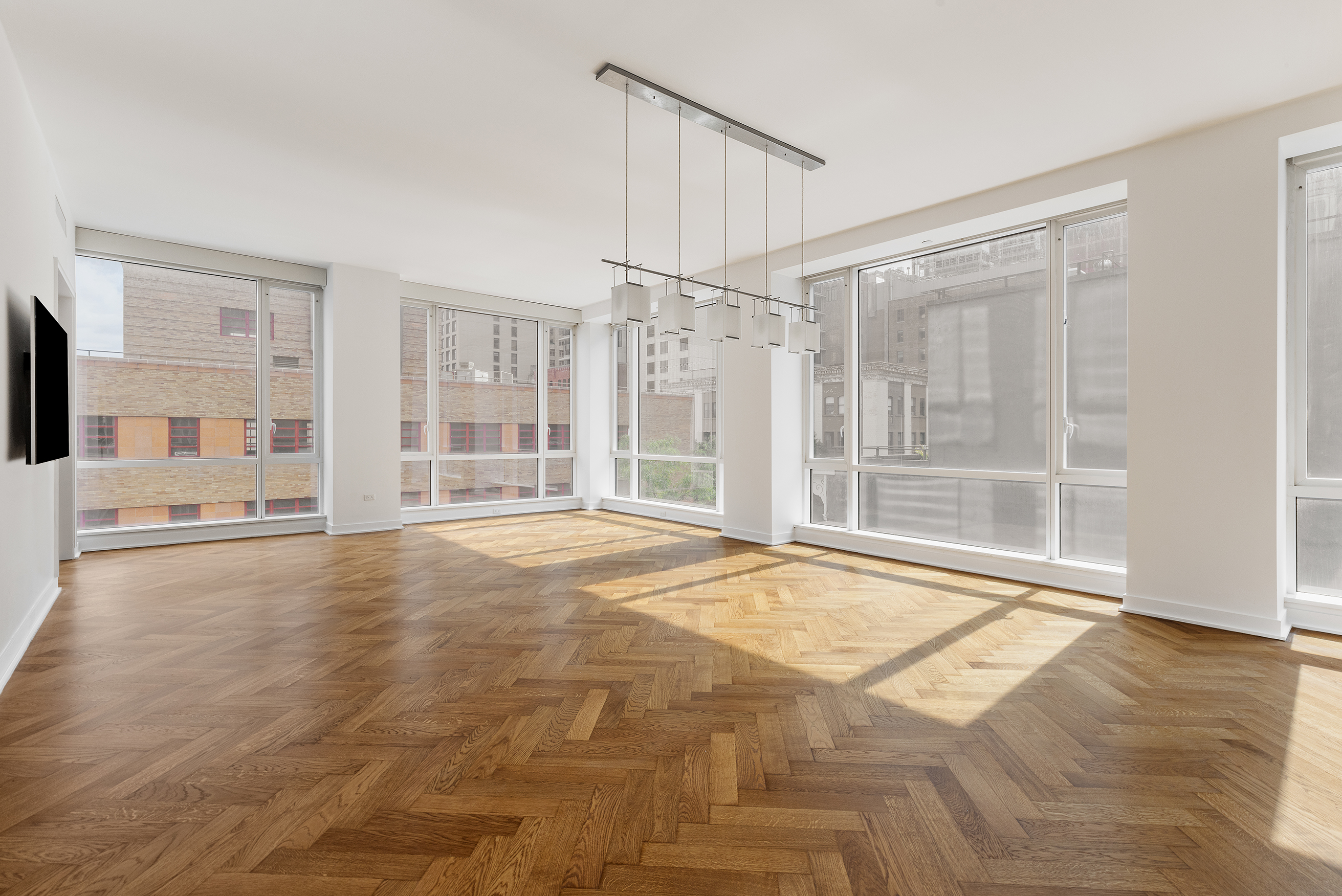 330 Spring Street, Unit 5A Manhattan, NY 10013 - Photo 4 of 13 a view of an empty room with wooden floor and a window