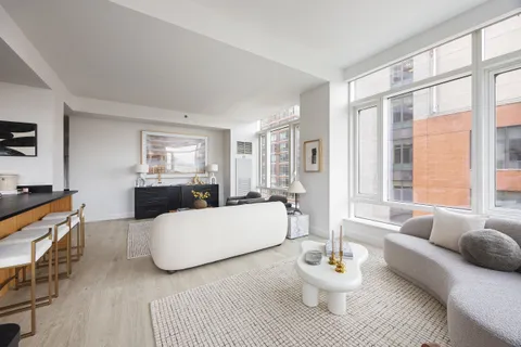 a living room with furniture a table and a large window