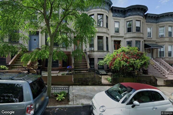 a front view of a house with yard and parking