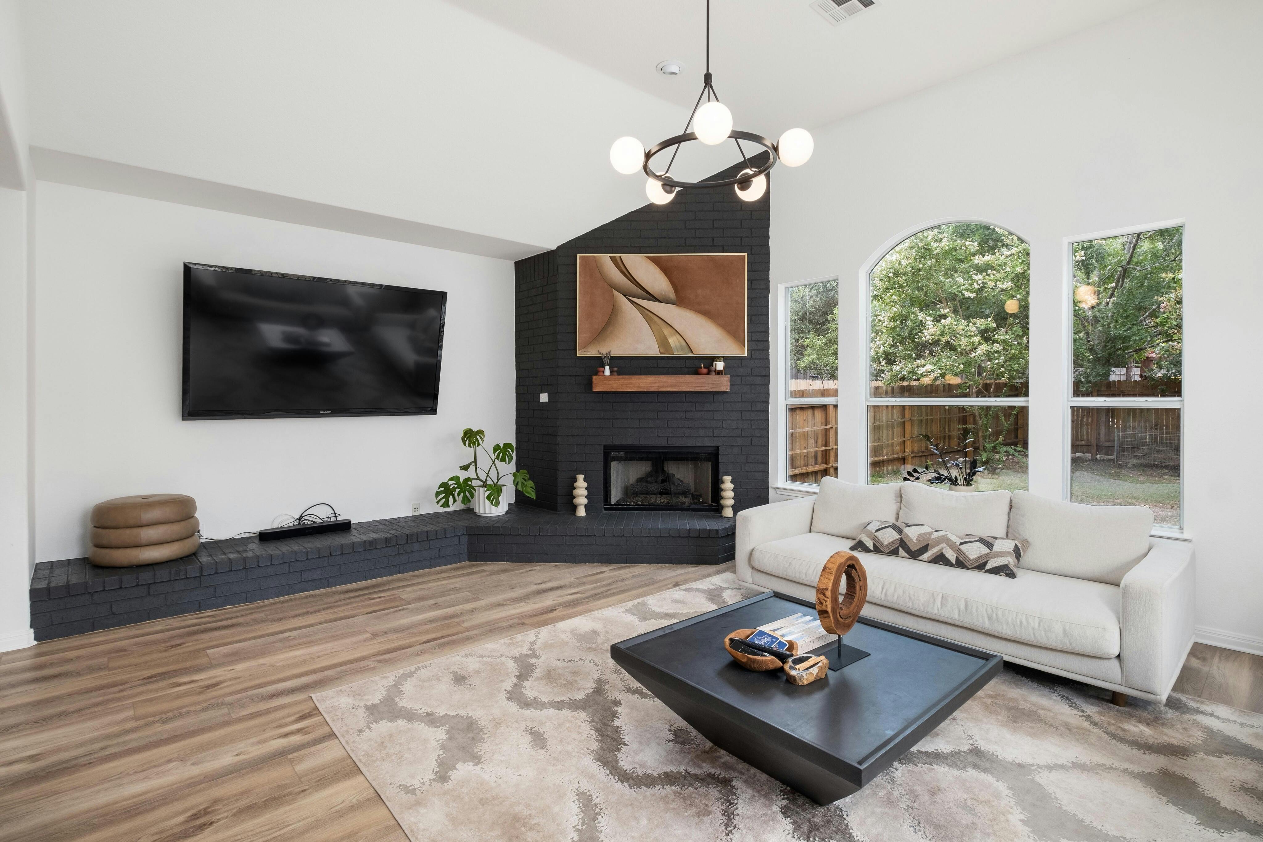 a living room with furniture a flat screen tv and a fireplace
