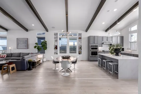 a living room with furniture and a dining table with wooden floor