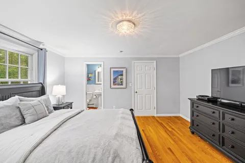 a bedroom with a bed dresser and a window
