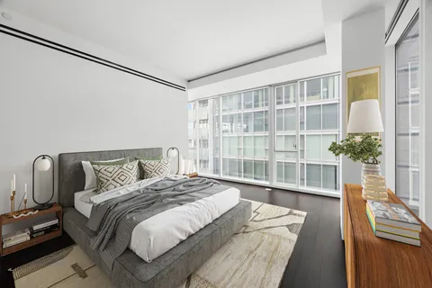 a large bed sitting in a bedroom next to a window