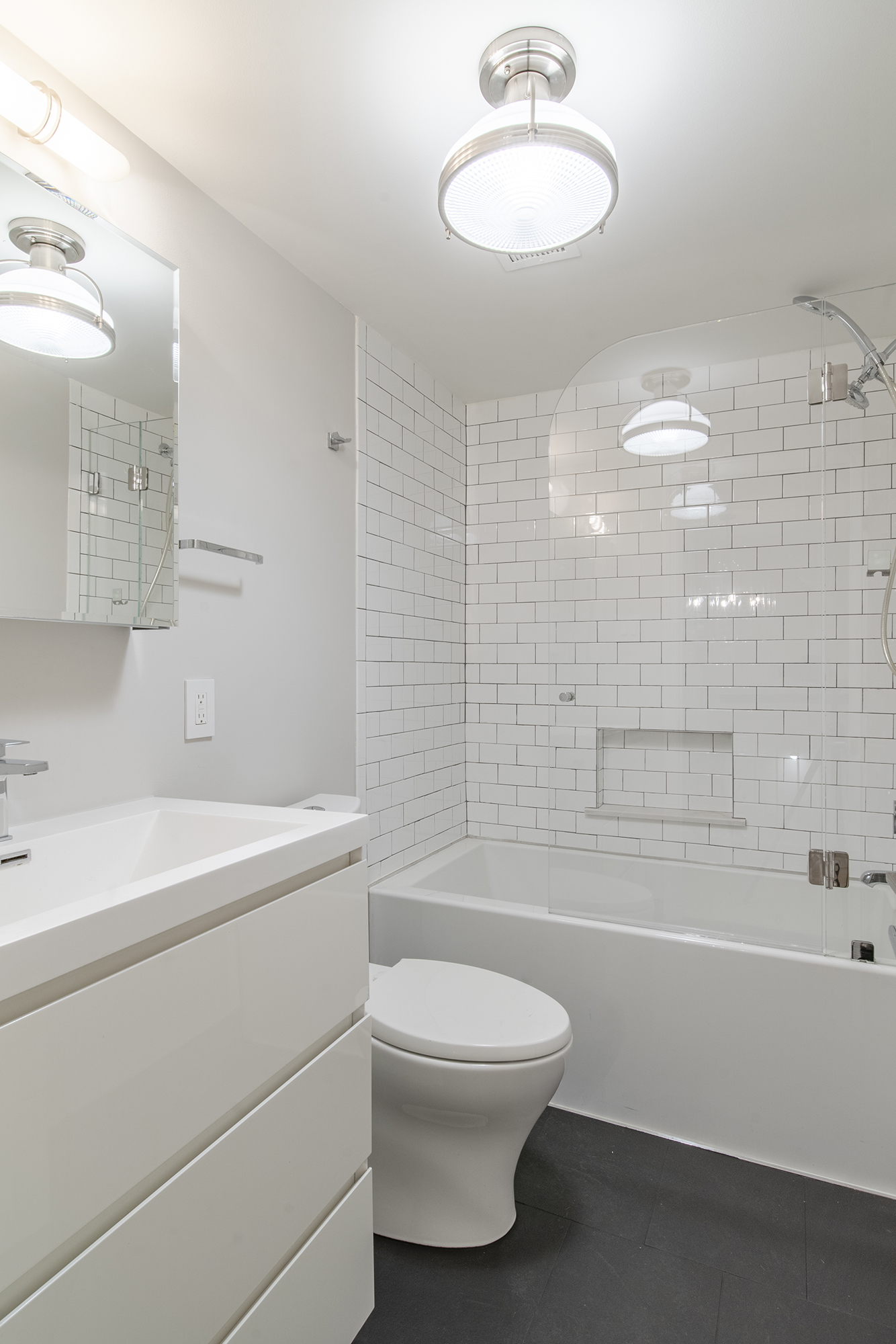 407 East 12th Street, Unit 1RSE Manhattan, NY 10009 - Photo 9 of 13 a bathroom with a toilet a sink a mirror a bathtub and shower
