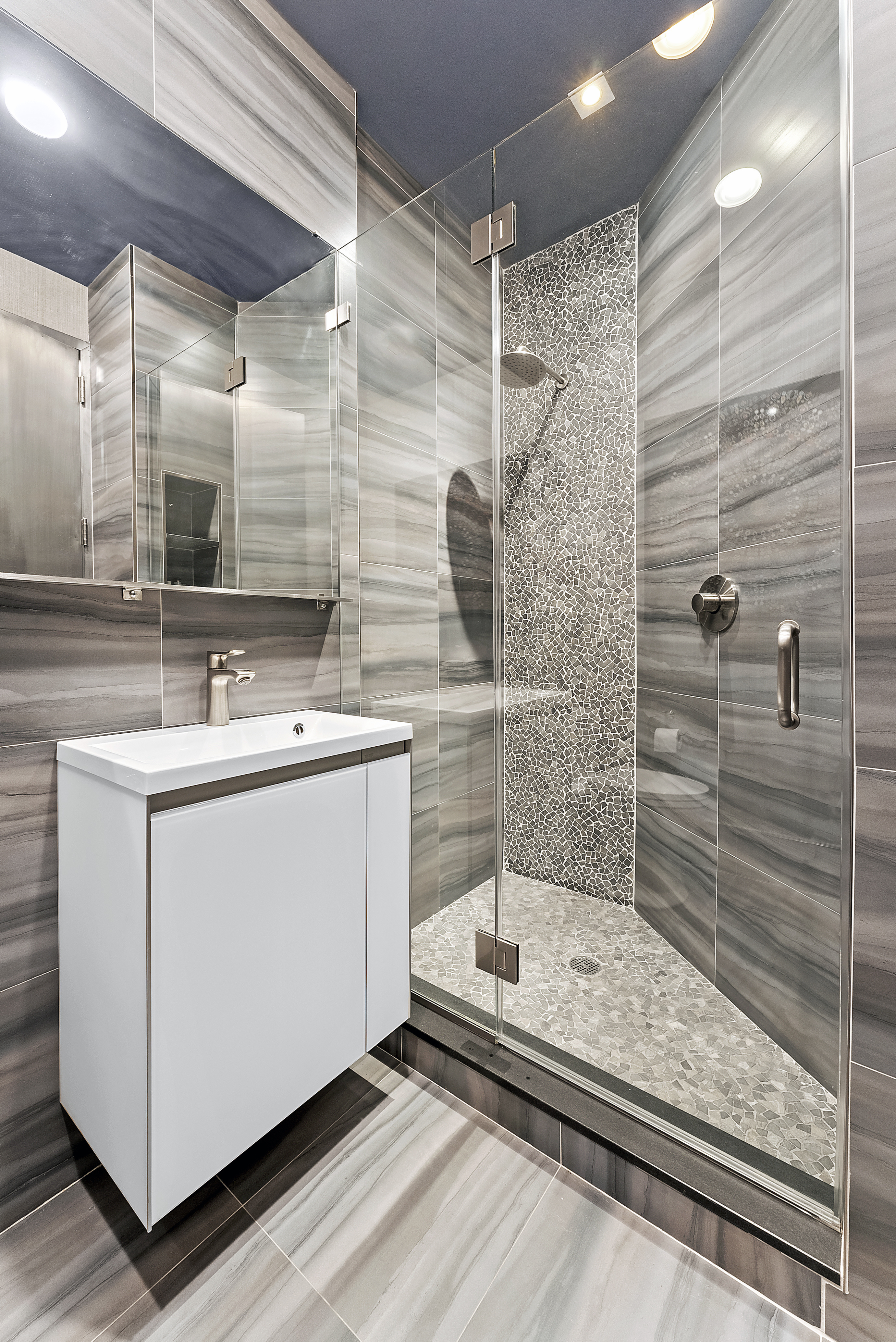 66 Leonard Street, Unit 2A Manhattan, NY 10013 - Photo 14 of 15 a bathroom with a sink a mirror and shower