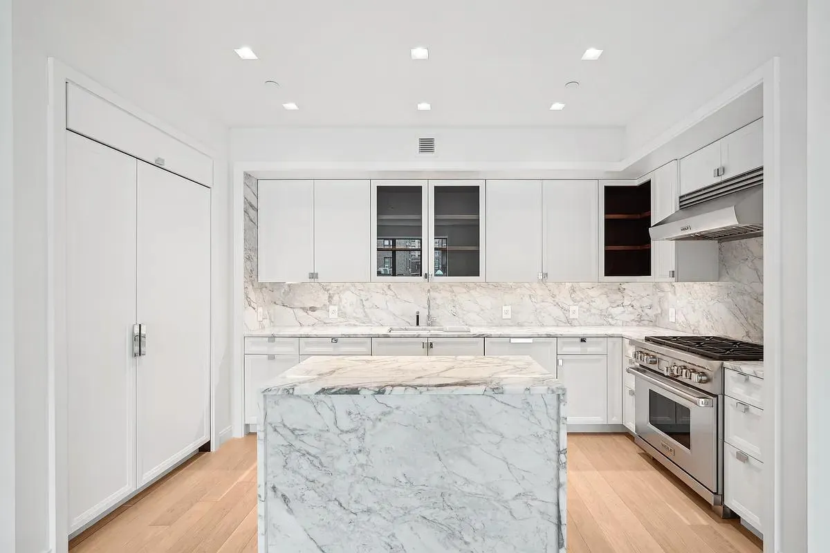 a large kitchen with stainless steel appliances granite countertop a stove and a sink