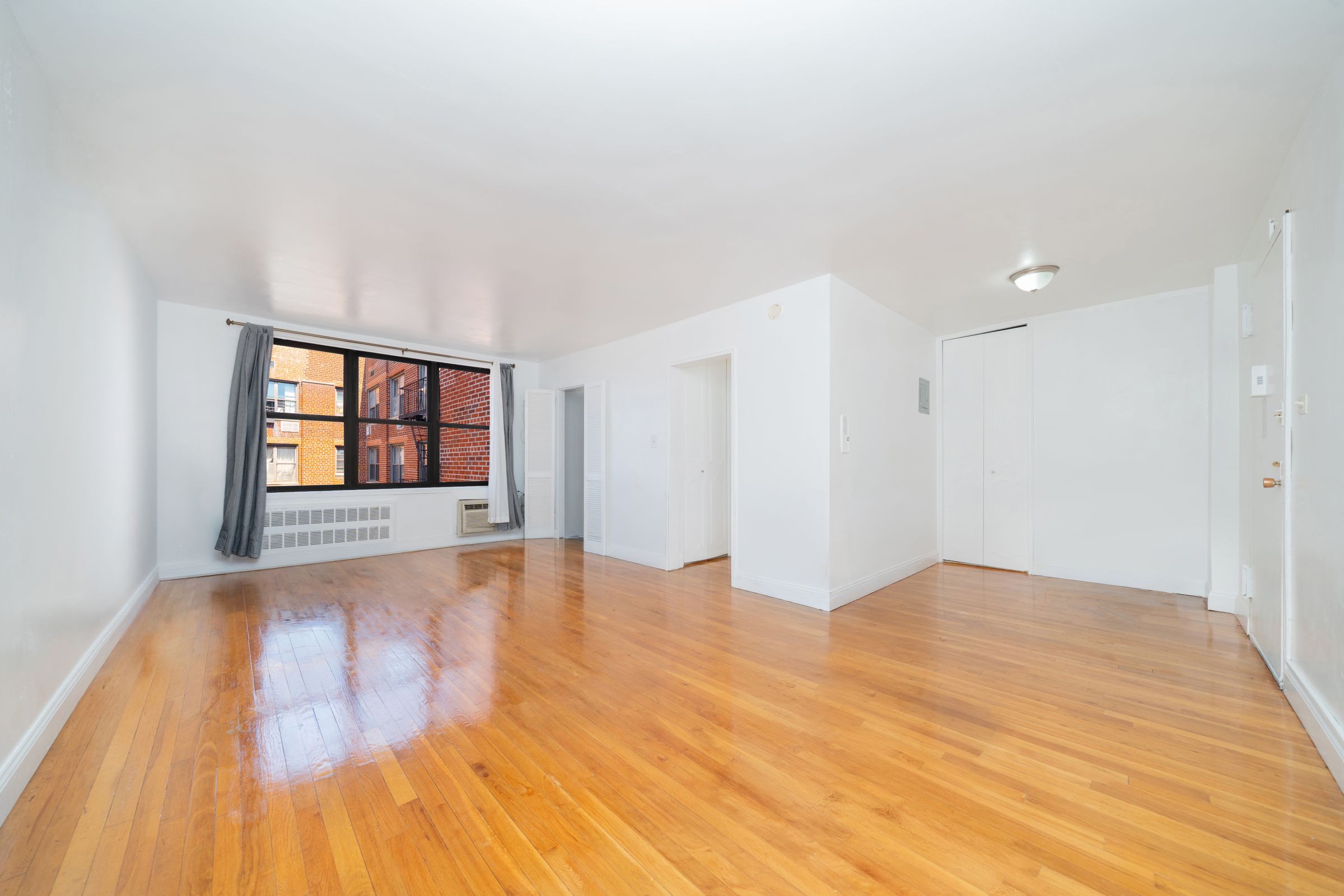 1270 East 51st Street, Unit 6M Brooklyn, NY 11234 - Photo 2 of 12 a view of an empty room with window and wooden floor