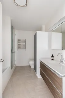 a bathroom with a sink a toilet and shower