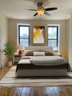 a bedroom with a bed window and potted plant
