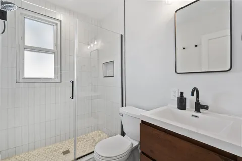 a bathroom with a sink a toilet and shower