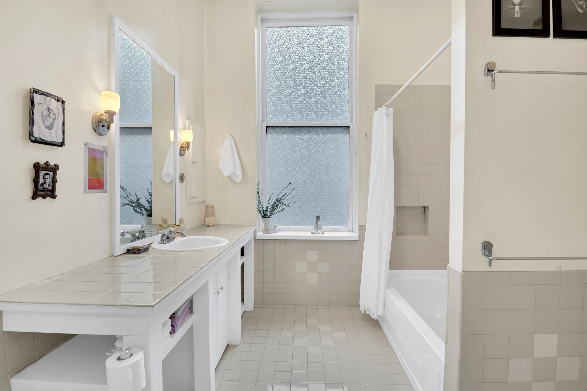 69 Wooster Street, Unit 3 Manhattan, NY 10012 - Photo 13 of 22 a bathroom with a granite countertop sink a mirror and a bathtub