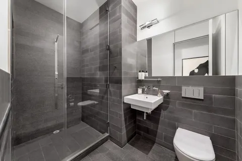 a bathroom with a sink a toilet and shower