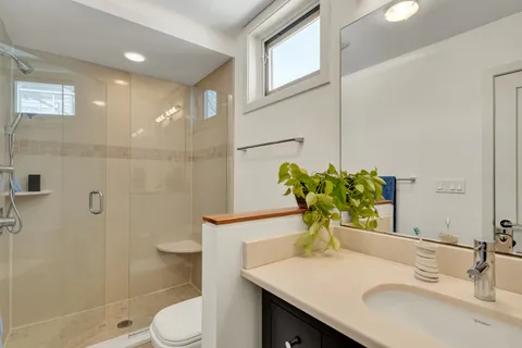 a bathroom with a sink a toilet and shower