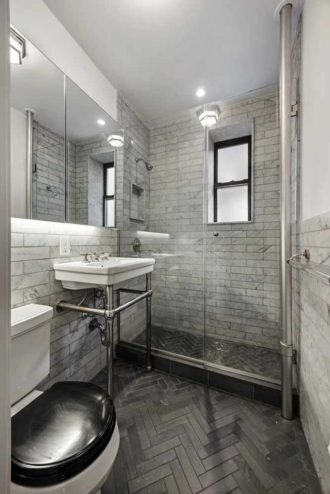 a bathroom with a sink a toilet and shower