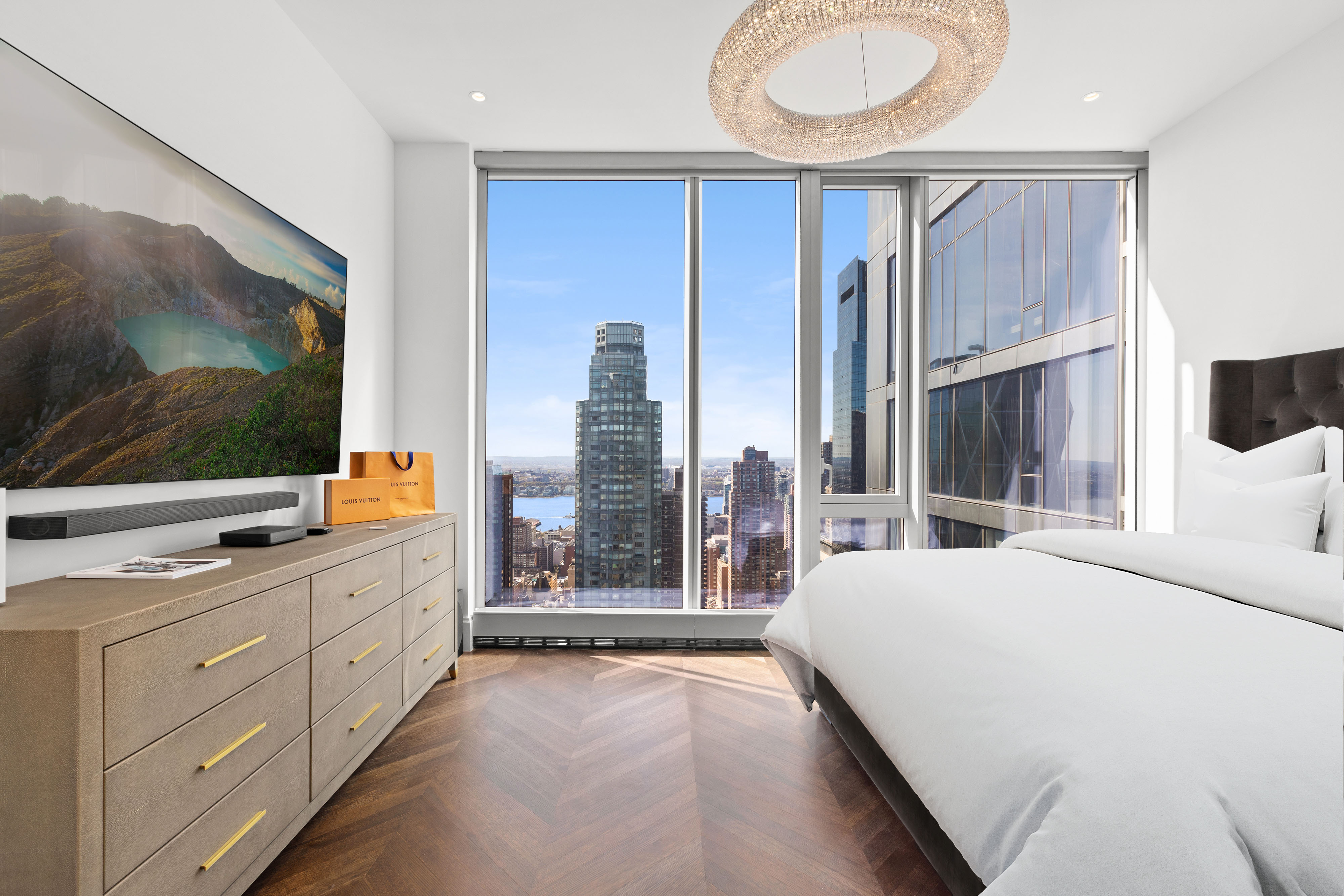 217 West 57th Street, Unit 48D Manhattan, NY 10019 - Photo 3 of 17 a bedroom with a bed and a flat screen tv
