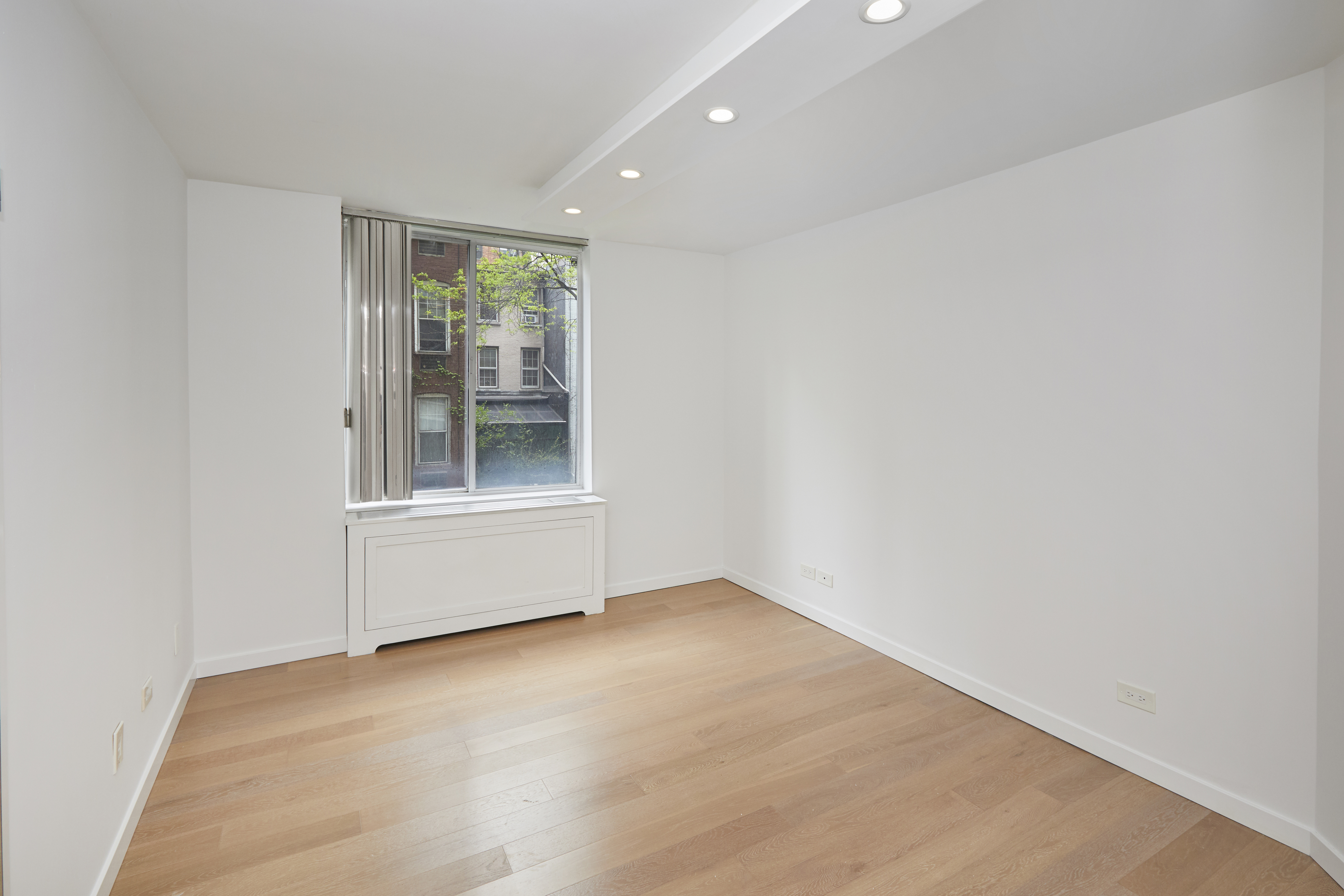 309 East 49th Street, Unit 3D Manhattan, NY 10017 - Photo 8 of 11 an empty room with sliding door and wooden floor