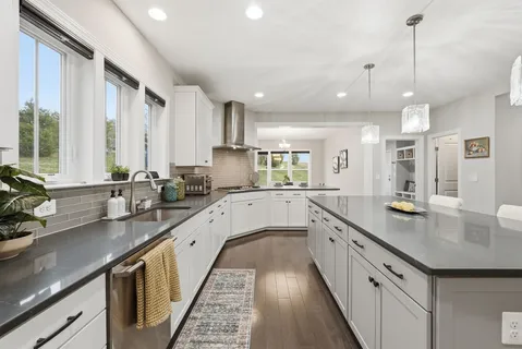 a large kitchen with granite countertop lots of counter space and sink