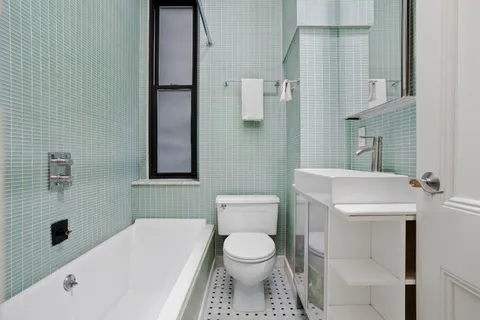 a bathroom with a toilet sink and mirror