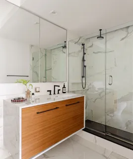 a bathroom with a sink mirror and shower