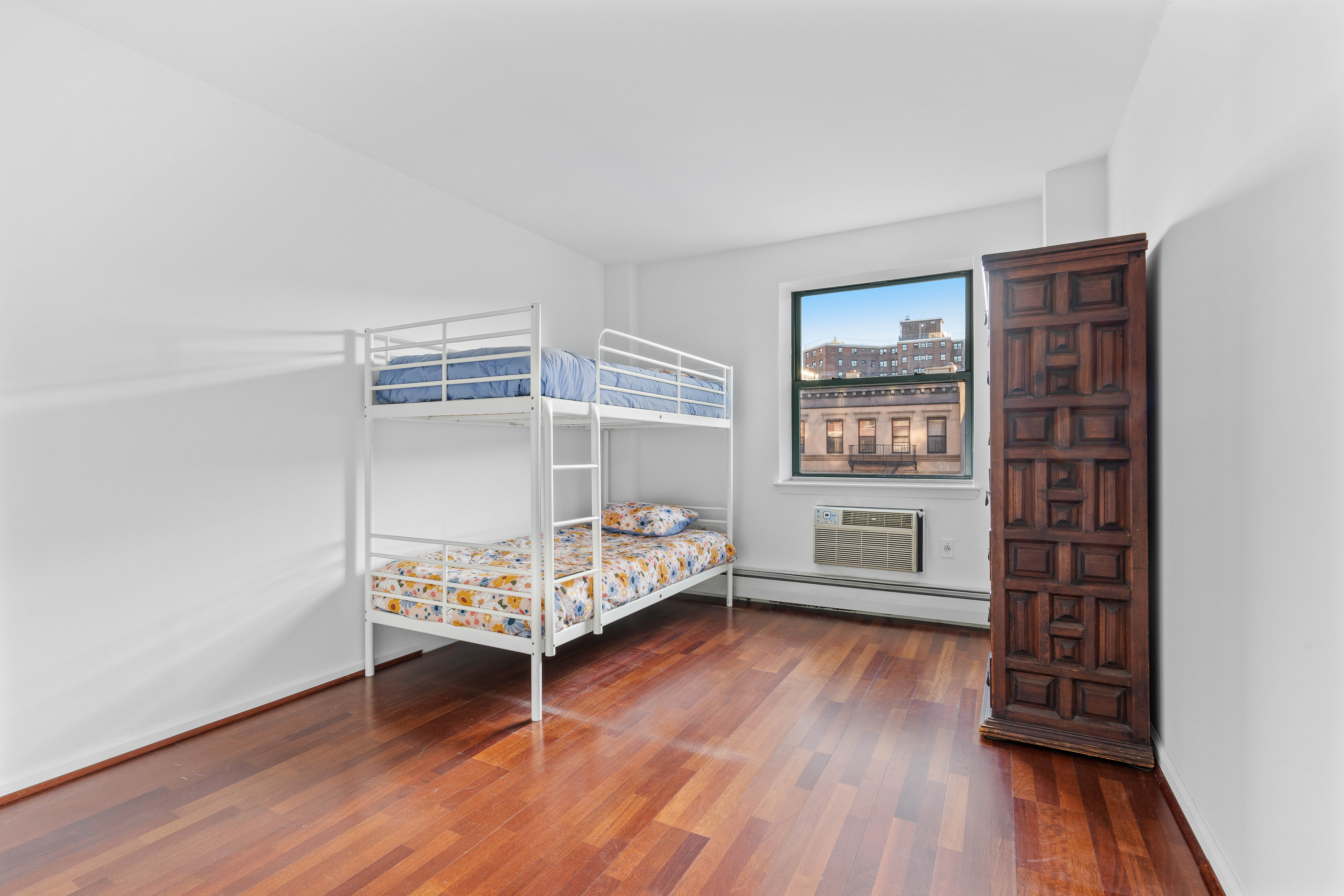 130 Lenox Avenue, Unit 522 Manhattan, NY 10026 - Photo 5 of 7 a bedroom with furniture and wooden floor