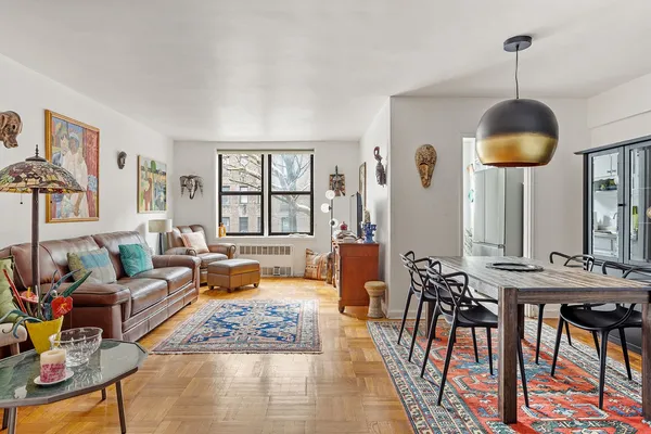 a living room with furniture kitchen view and a large window