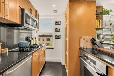 a kitchen with stainless steel appliances granite countertop a sink stove and cabinets