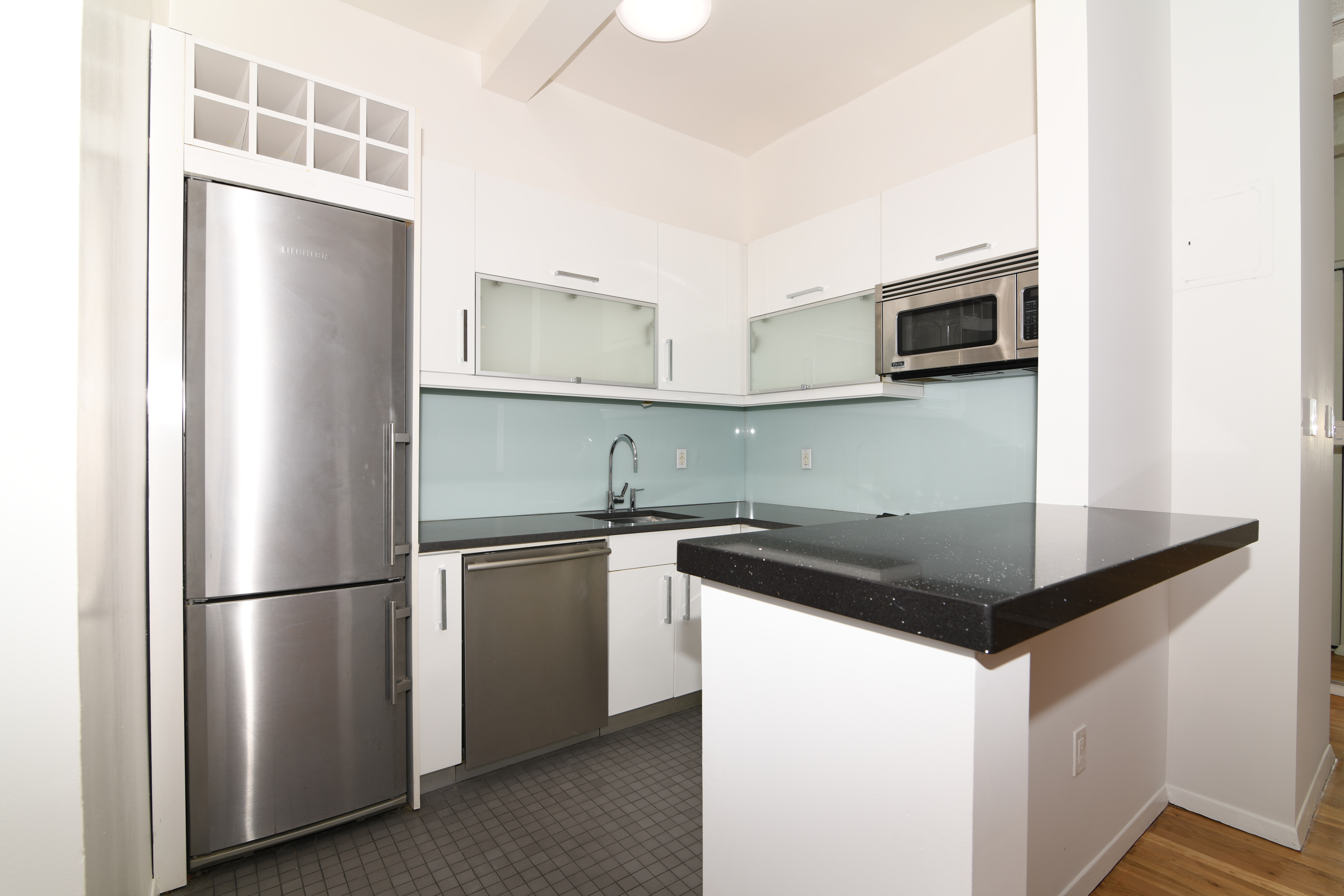 303 Mercer Street, Unit A601 Manhattan, NY 10003 - Photo 6 of 19 a kitchen with kitchen island a sink stove and refrigerator
