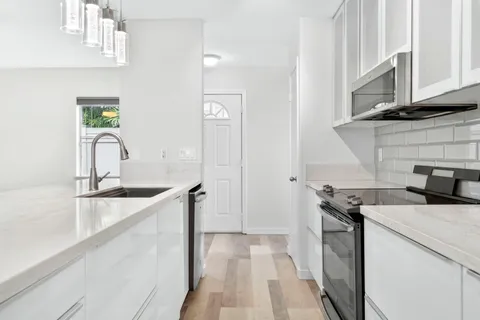 a kitchen with a sink stove and cabinets