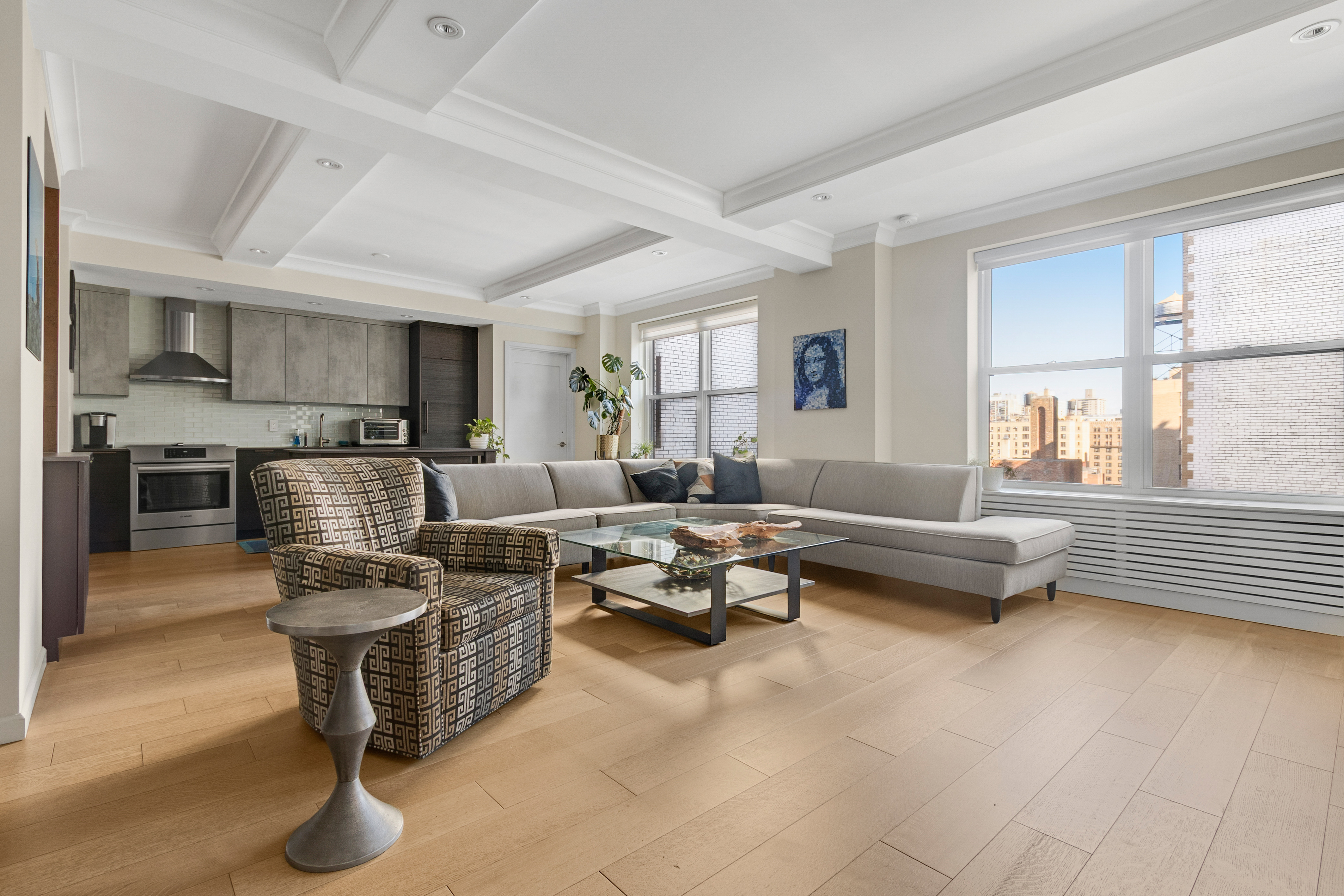 a living room with furniture wooden floor and a large window