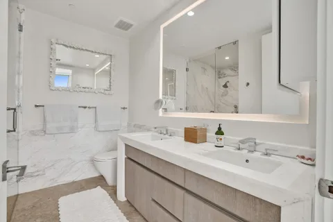 a bathroom with a sink a toilet and mirror