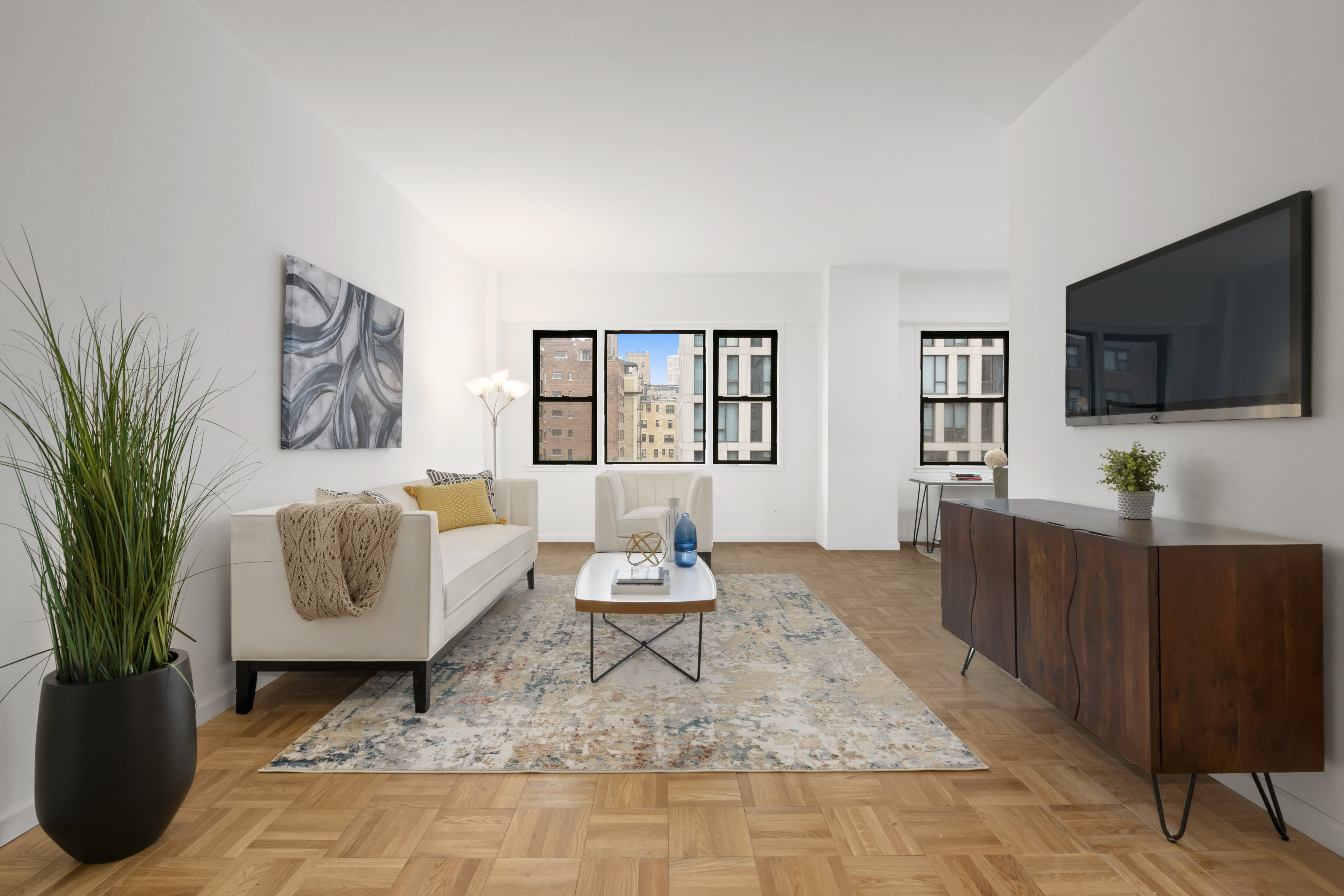 201 East 21st Street, Unit 15C Manhattan, NY 10010 - Photo 1 of 9 a living room with furniture and a flat screen tv