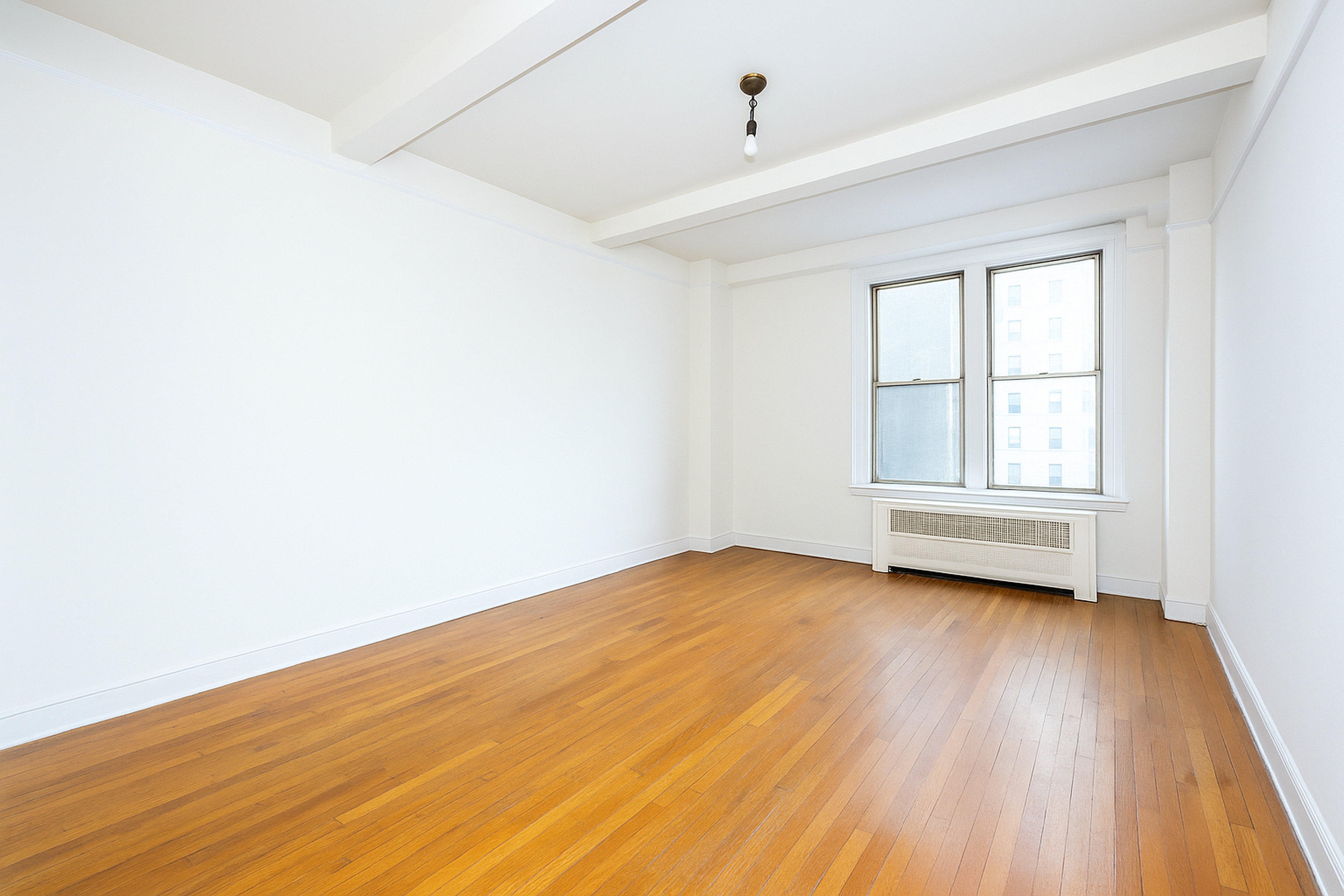12 West 96th Street, Unit 9A Manhattan, NY 10025 - Photo 5 of 9 an empty room with wooden floor and windows