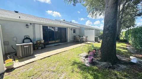 a view of a house with backyard and sitting area