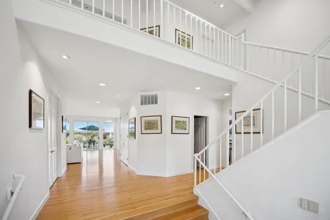 a view of a hallway with wooden floor and windows