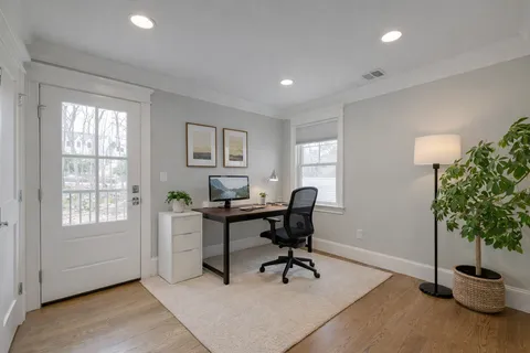 a view of a workspace with furniture and a window