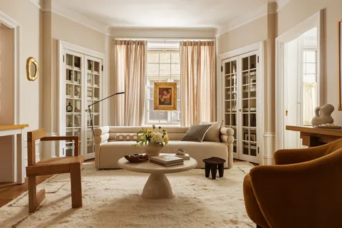 a living room with furniture and floor to ceiling windows