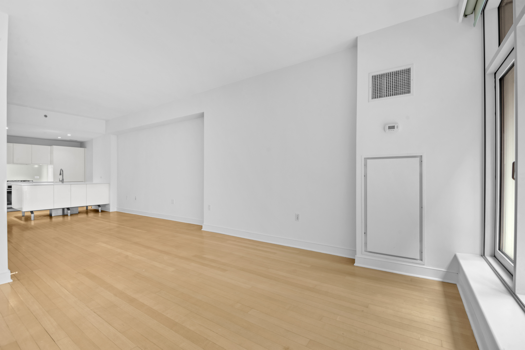 5 East 44th Street, Unit 5A Manhattan, NY 10017 - Photo 6 of 15 an empty room with kitchen and window