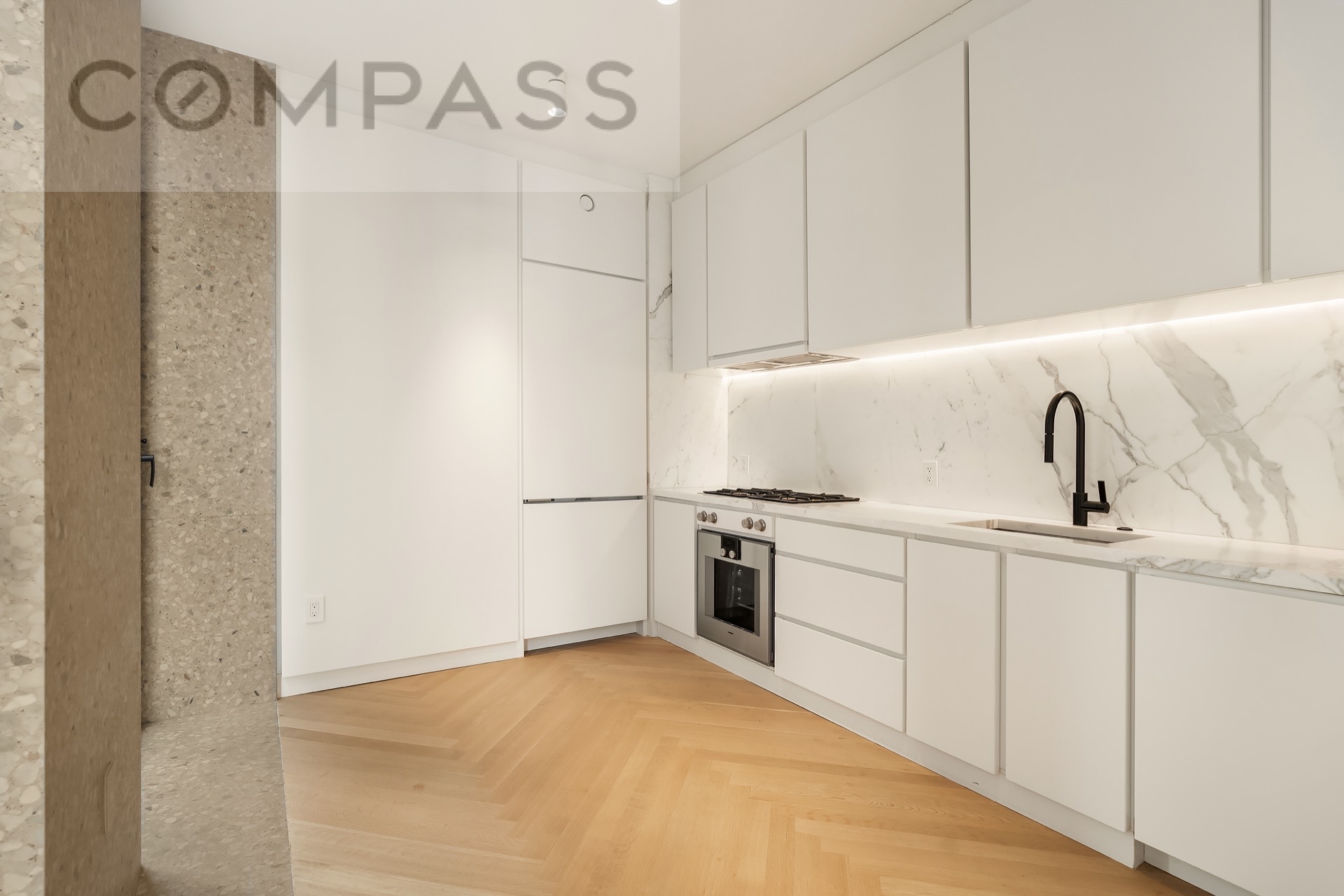 16 West 40th Street, Unit 21B Manhattan, NY 10018 - Photo 12 of 18 a kitchen with white cabinets and white appliances
