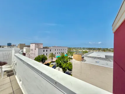 a view of a kitchen with kitchen island stainless steel appliances a sink and cabinets